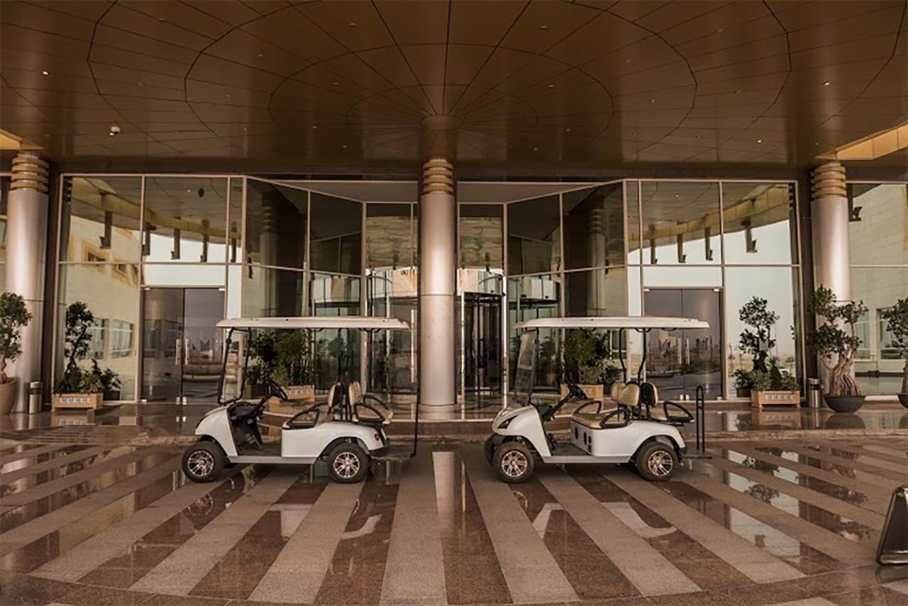 Millennium Hail Hotel Buitenkant foto Golf carts at the entrance of the hotel